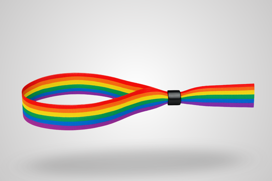 A photo of a fabric bracelet with a pride rainbow color pattern