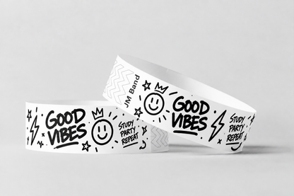 Duas pulseiras de papel brancas com desenhos impressos a preto